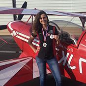 Natalya Shemigon in front of small plane holding a metal