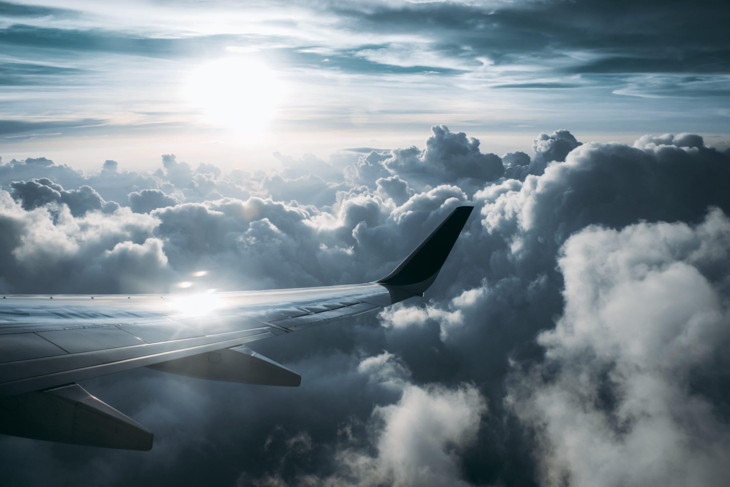 Passenger view of an airplane wing and the sky at sunset.