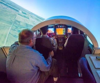 A faculty member giving instruction to 2 students in the jet simulation laboratory.